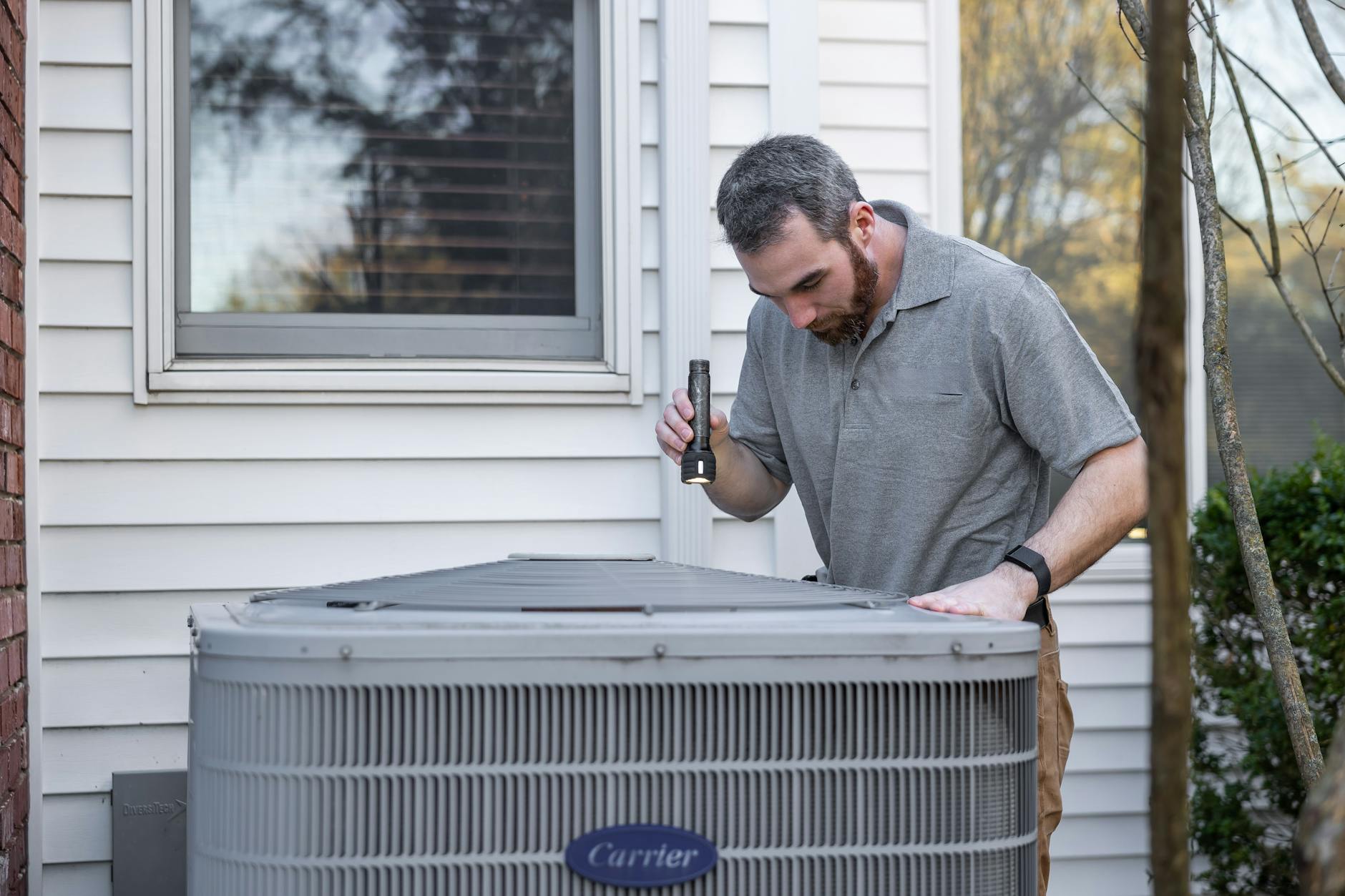 Professional HVAC technician inspecting outdoor unit